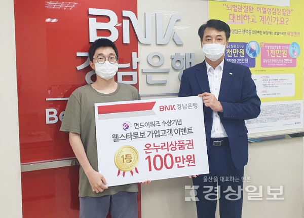 BNK경남은행 김남훈 영업점장(사진 오른쪽)이 BNK웰스타로보 가입고객 이벤트 1등 당첨자에게 ‘전통시장온누리상품권 100만원권 증서’를 전달하고 있다.