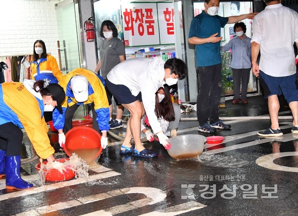 제12호 태풍 ‘오마이스’로 인한 집중호우로 24일 새벽 울산시 중구 태화시장 일대가 한때 물에 잠기는 피해를 입었다. 상인들과 중구청 공무원, 소방대원들이 복구작업을 하고 있다. 김동수기자 dskim@ksilbo.co.kr