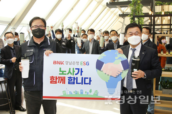 지난 5일 BNK경남은행 본점 로비에서 진행된 ‘ESG경영 실천 이벤트’에서 BNK경남은행 최홍영 은행장(사진 오른쪽)과 BNK경남은행노동조합 최광진 위원장이 ‘BNK경남은행 ESG 노사가 함께 합니다’라고 적힌 피켓을 들고 기념촬영하고 있다.