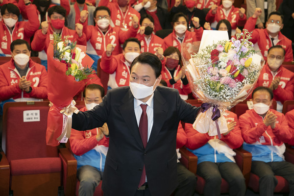 윤석열 제20대 대통령 당선인이 10일 새벽 서울 여의도 국회도서관에 마련된 '국민의힘 제 20대 대통령선거 개표상황실'에서 꽃다발을 들고 포즈를 취하고 있다.  [국회사진기자단]