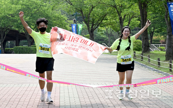 평소 마라톤을 즐기는 김도현(44)·신소연(44)씨 커플이 ‘내사랑 여니, 앞으로도 계속 행복하자 사랑해요’라는 현수막을 함께 들고 완주선을 통과하고 있다.