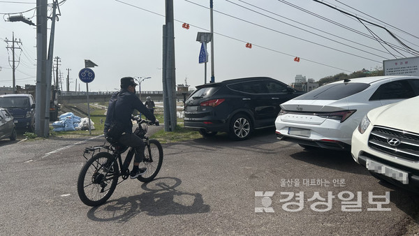 30일 오전 10시께 울산 중구 동동으로 향하는 자전거 이용자가 산전교 앞을 막아선 차량들 사이로 지나가고 있다.