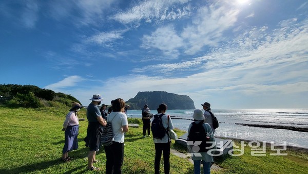 제주 성산일출봉 일대의 4·3유적지에서 팸투어 참가자들이 당시 무자비한 토벌대의 학살에 대한 설명을 듣고 있다. 제주다크투어 제공