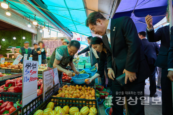 이재명 대통령과 김혜경 여사가 6일 서울 동작구 남성시장을 방문해 과일을 고르고 있다. 대통령실 제공.